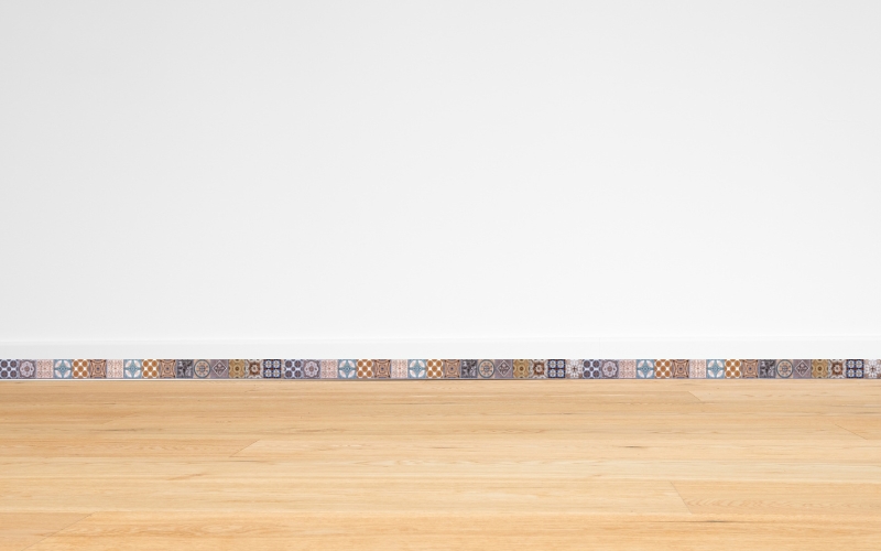 Gạch ốp chân tường họa tiết và nền gỗ sáng