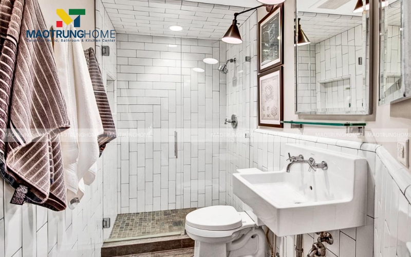Nhà vệ sinh nhỏ kết hợp gạch thẻ trắng và tranh treo tường cá tính