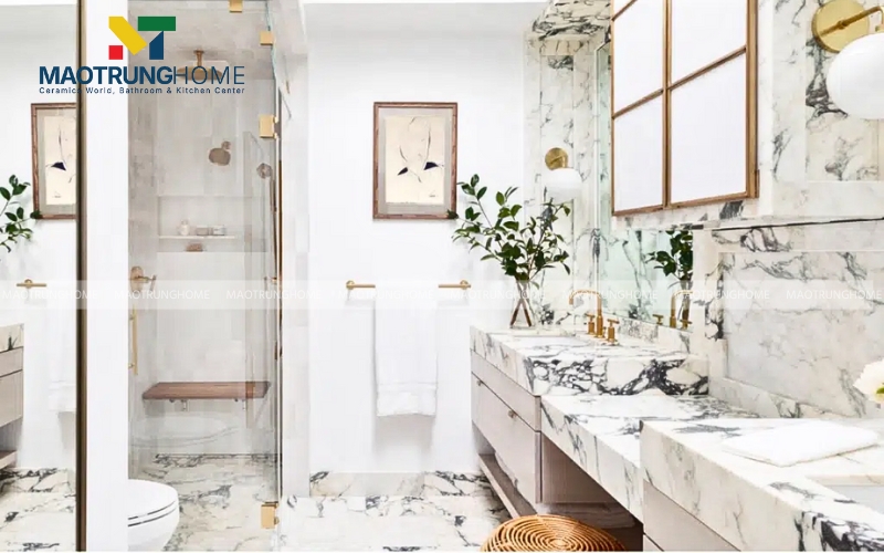 Thiết kế nhà vệ sinh với gạch ốp tường vân đá tự nhiên khổ lớn cùng bình hoa xanh mát