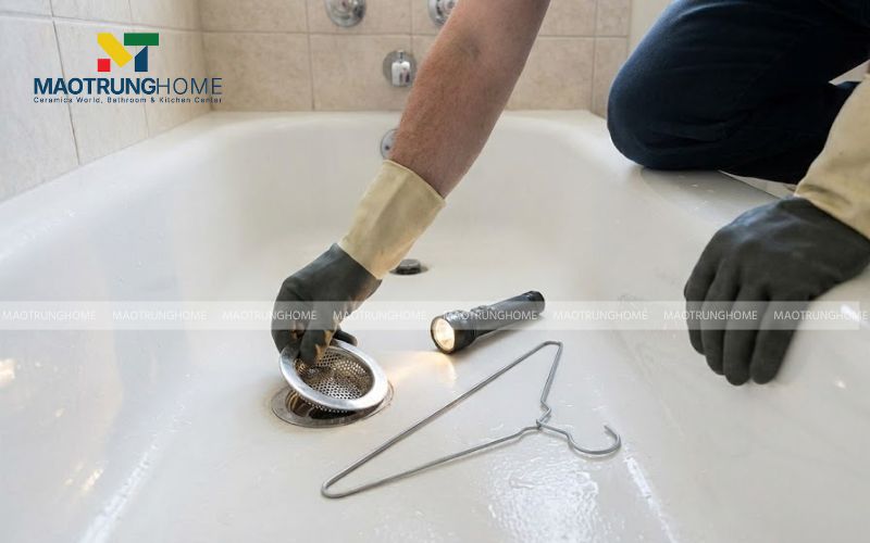 Tháo nắp lưới lọc rác ở miệng cống thoát nước